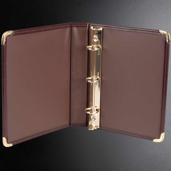Brown leather binder with gold hardware on a dark background