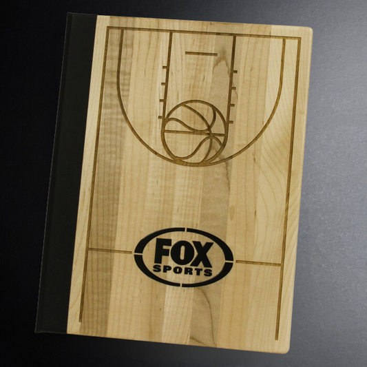 Wooden board with basketball court design and Fox Sports logo on a dark surface