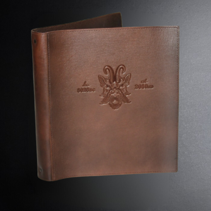Brown leather menu cover with embossed logo and text on a dark background