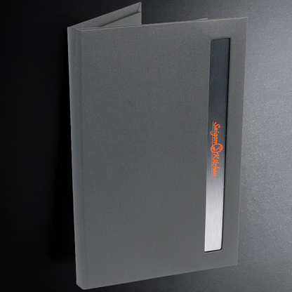 Gray menu cover with a logo on a dark background