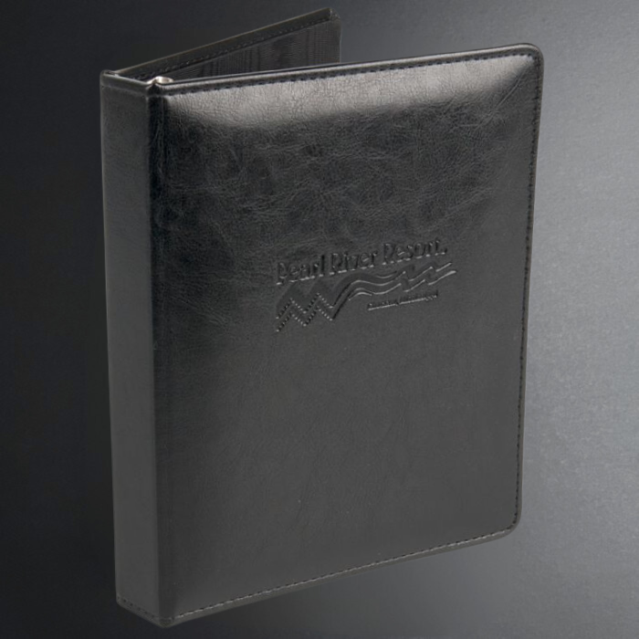 Black leather-bound book with embossed logo on a gray background