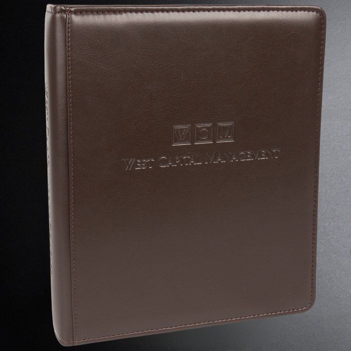 Brown leather notebook with 'West Capital Management' embossed on a gray background