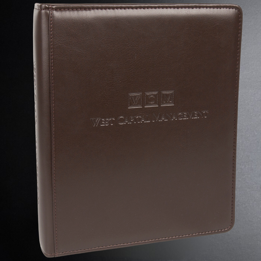 Brown leather notebook with 'West Capital Management' embossed on a gray background