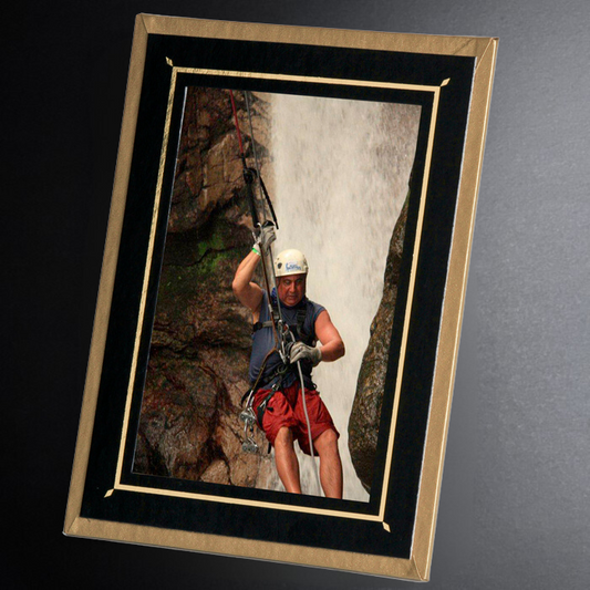 Framed photo of a person rappelling on a rocky cliff face.
