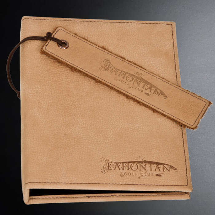 Brown leather notebook with strap and 'Eaton Tan Golf Club' branding on a gradient background