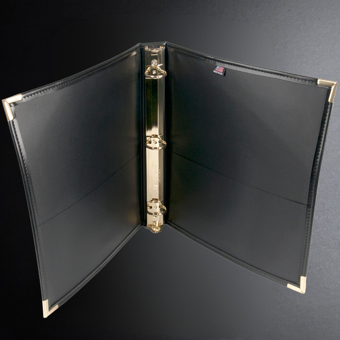 Black leather binder with gold hardware on a dark background