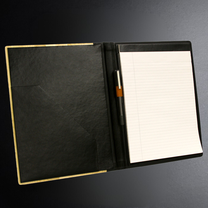 Black leather portfolio with a pen holder and lined paper on a dark background