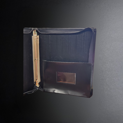 Black folder with a gold clip on a dark gray background