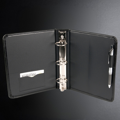Black leather portfolio with three-ring binder and pen on a dark background