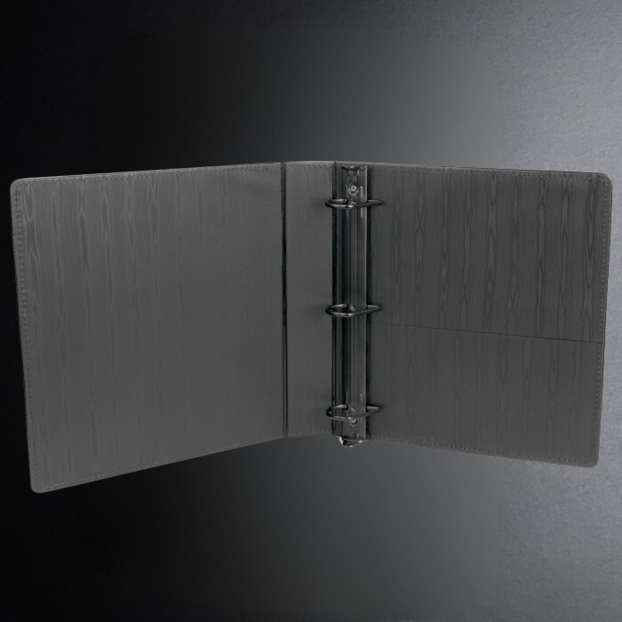 Black leather-bound book with a metal ring binder on a dark gray background