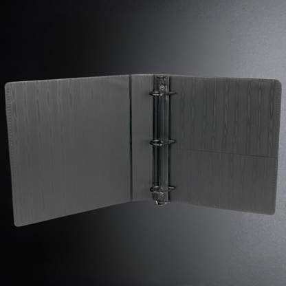 Black leather-bound book with a metal ring binder on a dark gray background