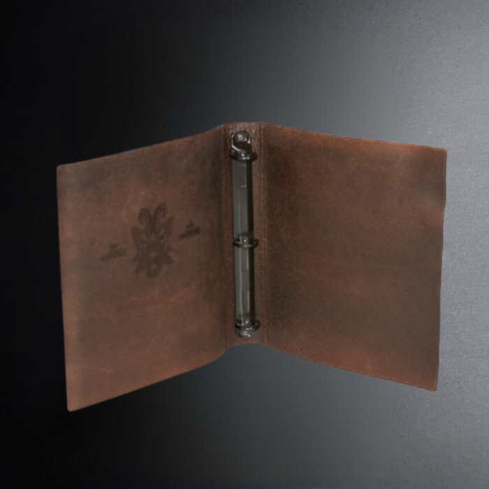 Brown leather notebook with metal ring on a gradient gray background