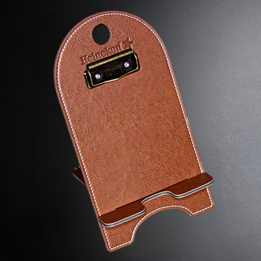 Brown leather bottle holder with Heineken logo on a dark background
