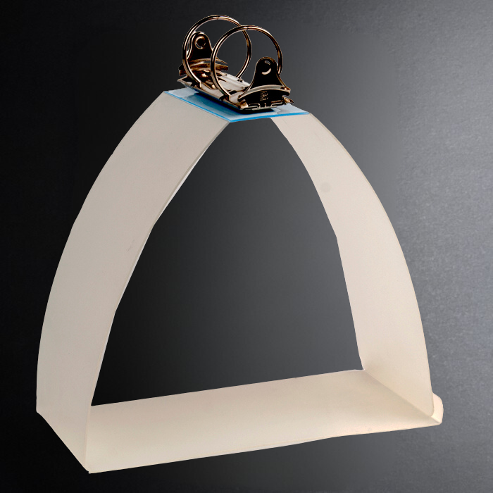 White triangular shelf with a metallic object on a dark background