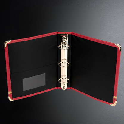 Red-bound binder with black interior on a dark background