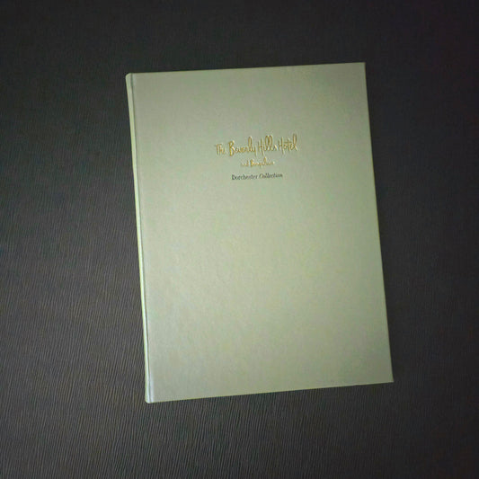A green Beverly Hills Hotel guest folder with debossed gold text on the cover.