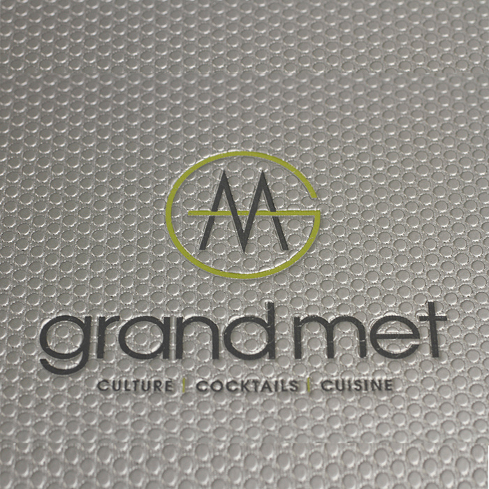 Gray textured surface with 'grand met' logo and text