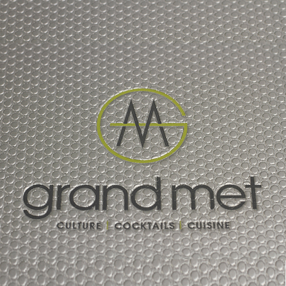 Gray textured surface with 'grand met' logo and text