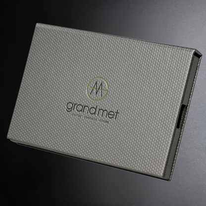 Gray textured box with 'grand met' branding on a dark background