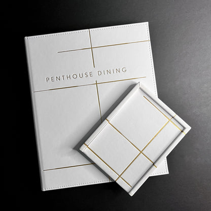 A white Vienna tray with gold felt bottom and gold foil debossing on the cover, labeled 'Penthouse Dining'.