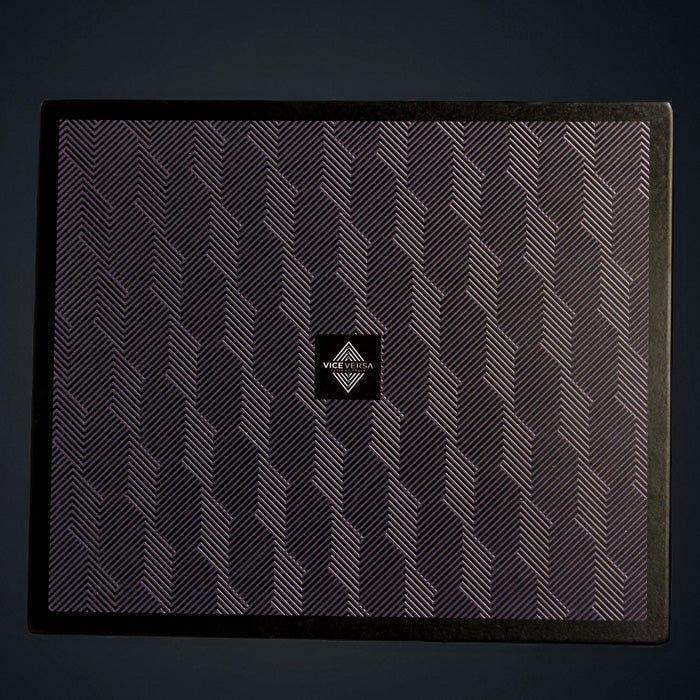 A rectangular wooden placemat with a geometric pattern in black and purple colors and a visible brand logo in the center.