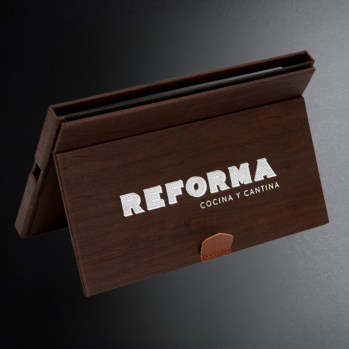 Brown leather menu cover with 'Reforma Cocina y Cantina' text on a dark background