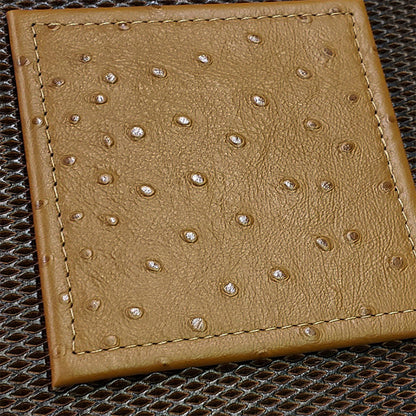 A brown square stitched coaster with a textured surface on a mesh background.