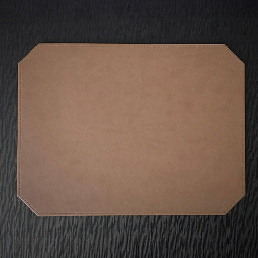 A rectangular placemat with mitered corners, Italian faux leather construction, and a visible stitched edge.