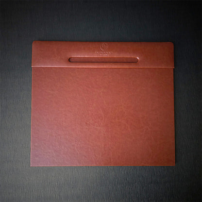A rectangular desk blotter with Italian faux leather cover in brown, featuring a debossed logo on the top edge.