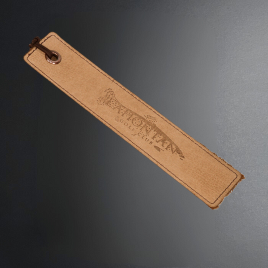 Brown leather strap with a brand logo on a dark gray background