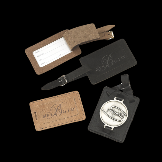 Collection of leather luggage tags with branding on a black background