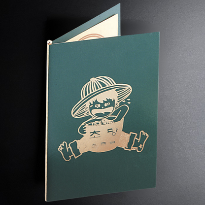 Green notebook with a white illustration of a character on a dark background
