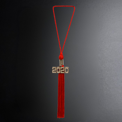 Red tassel with '2020' charm on a dark background