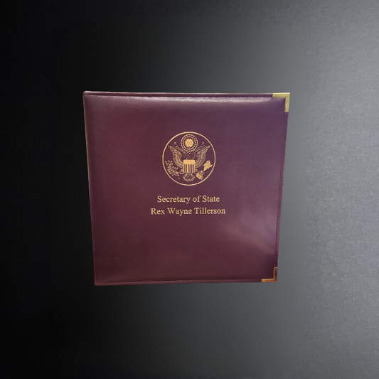 Maroon folder with gold emblem and text on a dark gray background