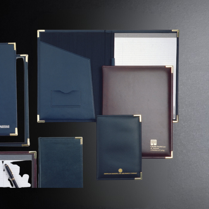 Collection of leather-bound books and notebooks on a dark background