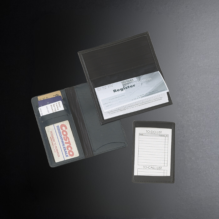 Black cardholder with various cards and a small pad on a dark surface