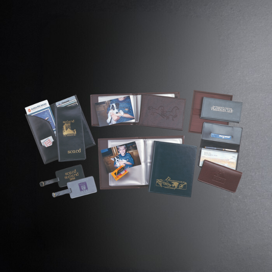 Collection of leather-bound photo albums and accessories on a dark surface