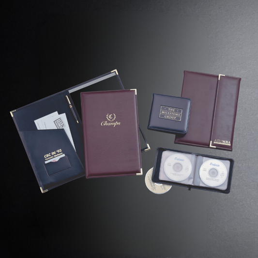 Collection of leather-bound books and folders on a dark surface