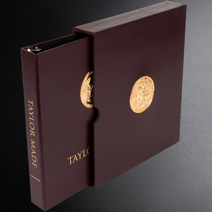Maroon binder with gold embossed logo on a gray background