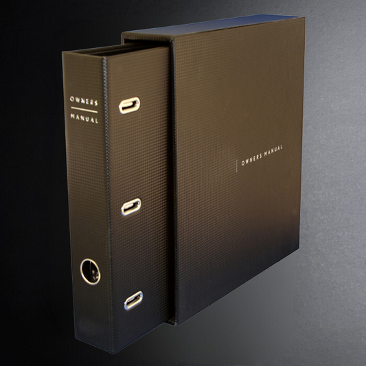Brown ring-bound manual with 'Owners Manual' text on a gradient background