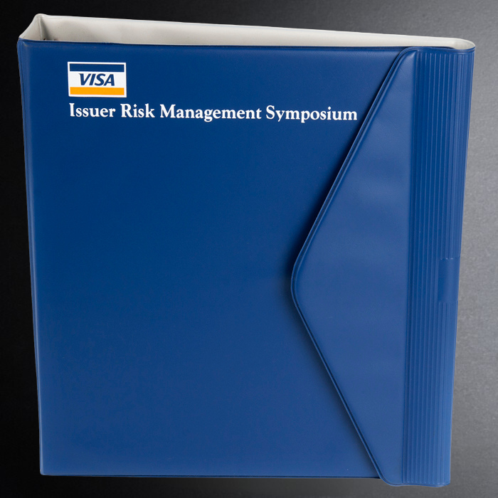Blue binder with Visa logo and 'Issuer Risk Management Symposium' text on a gray background