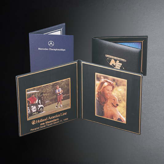 Two open photo albums with printed images on a dark background