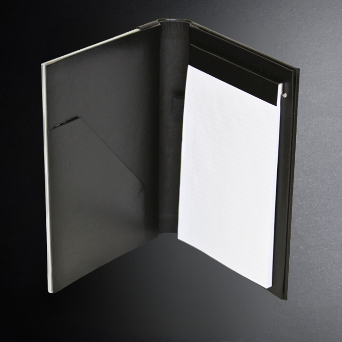 Black leather-bound book with a white page on a dark background